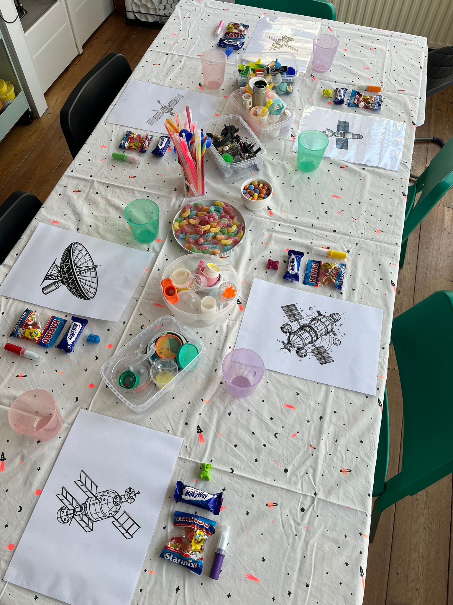 Een feestelijk versierde tafel met snoepjes, drinken en een creatief feestje over de ruimte.